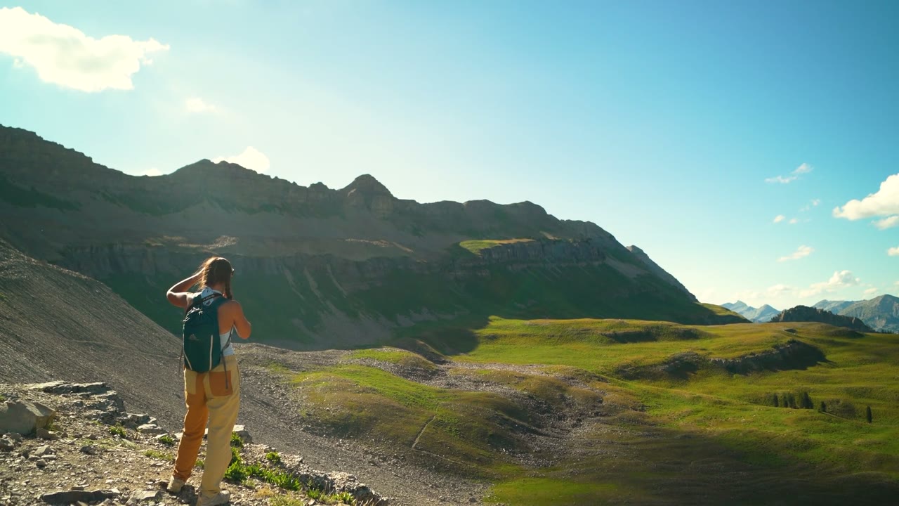 A hiker looking over green mountains
